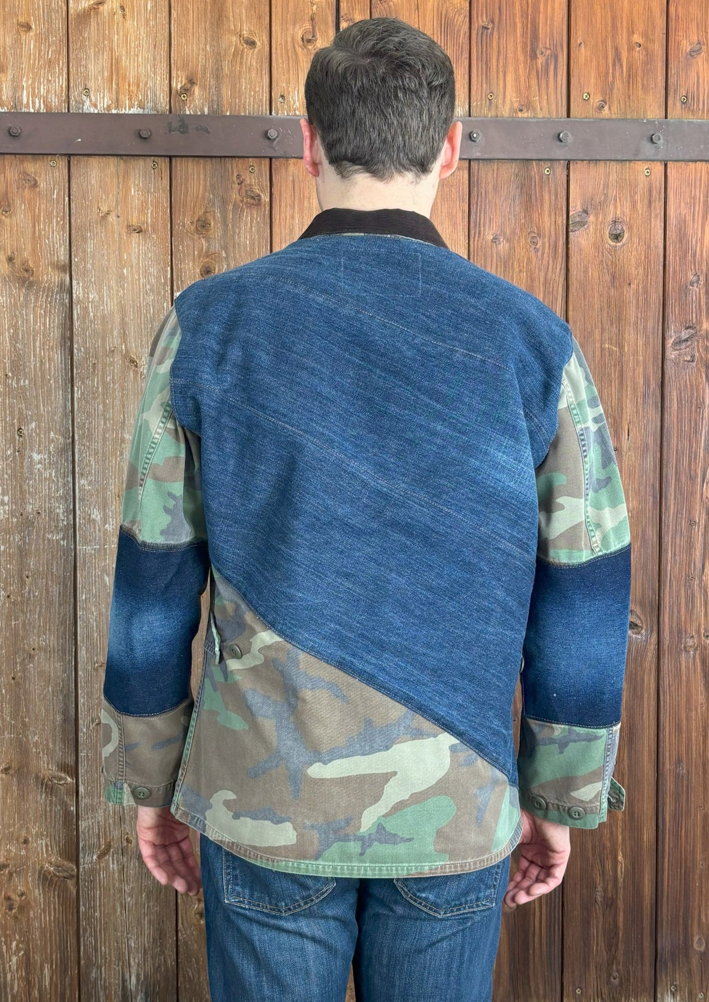 Diagonal verlaufender breiter Denim-Stoff auf der Rückseite der Camouflage-Jacke, mit dem unteren Teil weiterhin im Camouflage-Muster.